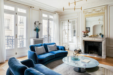 Modernes Wohnzimmer mit weißer Wandfarbe, hellem Holzboden, Kamin, beigem Boden und vertäfelten Wänden in Paris