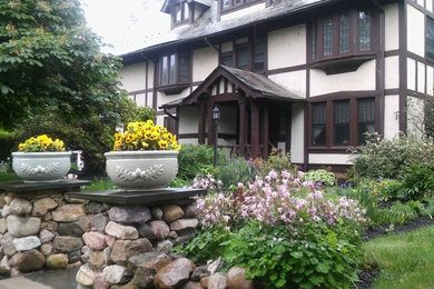 This is an example of a mid-sized traditional full sun front yard mulch formal garden in New York.