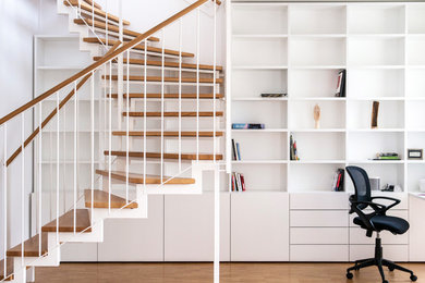 Große, Gewendelte Moderne Treppe mit gebeizten Holz-Treppenstufen, offenen Setzstufen und Mix-Geländer in Berlin