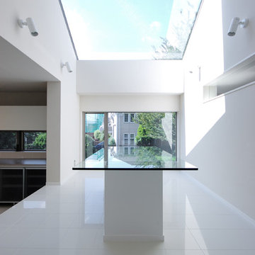 北側に大きく開けたトップライトとその光を1階まで届か設ための、ガラスのテーブルです。 覗くと下階の和室の天井についている障子が見えます。 下階は親世帯です。