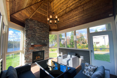 Inspiration for a rustic sunroom remodel in Other with a stone fireplace