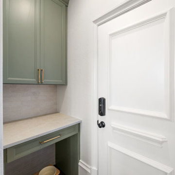 Sage green mudroom nook with custom pet feeding station and built-in cabinetry
