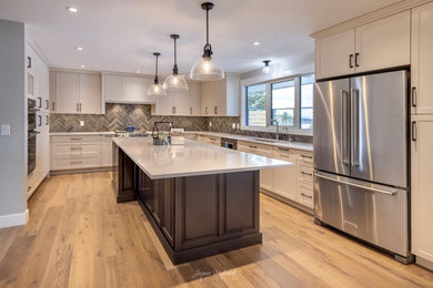 Inspiration for a huge transitional u-shaped medium tone wood floor and brown floor eat-in kitchen remodel in Calgary with an undermount sink, shaker cabinets, white cabinets, quartz countertops, multicolored backsplash, subway tile backsplash, stainless steel appliances, an island and white countertops