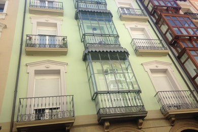 Ejemplo de fachada verde clásica de tres plantas con revestimientos combinados