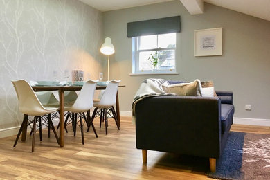 This is an example of a medium sized scandi open plan dining room in Other with grey walls, laminate floors, no fireplace and brown floors.