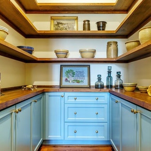 Inspiration pour une arrière-cuisine rustique en U avec un placard à porte shaker, des portes de placard bleues, un plan de travail en bois, un sol en bois foncé, un sol marron et un plan de travail marron.