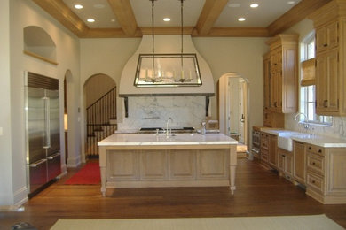 Example of a large classic u-shaped dark wood floor and brown floor eat-in kitchen design in Indianapolis with a farmhouse sink, raised-panel cabinets, light wood cabinets, marble countertops, stainless steel appliances, white backsplash, stone slab backsplash and an island