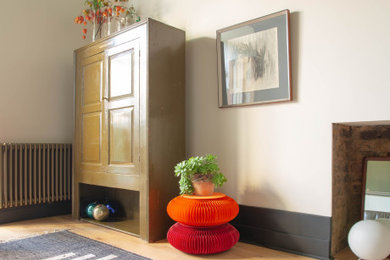 Inspiration for a large bohemian living room in London with white walls, medium hardwood flooring and a concealed tv.