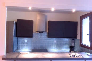 Idée de décoration pour une cuisine ouverte parallèle design de taille moyenne avec une crédence grise, une crédence en carreau de verre et un électroménager en acier inoxydable.