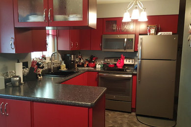 Inspiration for a small contemporary u-shaped vinyl floor eat-in kitchen remodel in Other with a single-bowl sink, flat-panel cabinets, red cabinets, laminate countertops, gray backsplash, metal backsplash, stainless steel appliances and a peninsula