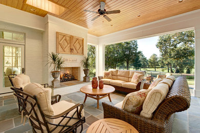 Example of a classic tile patio design in Charlotte with a fire pit and a roof extension