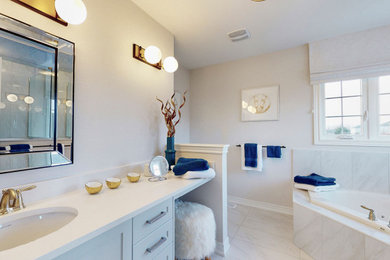 トロントにあるトランジショナルスタイルのおしゃれなマスターバスルーム (グレーのキャビネット、コーナー型浴槽、白い洗面カウンター、洗面台1つ、造り付け洗面台) の写真