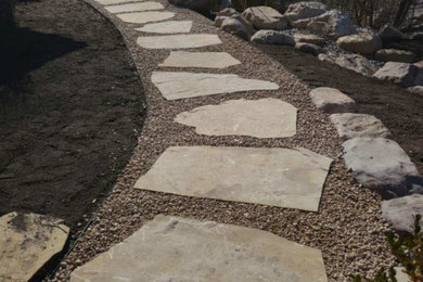 Inspiration for a mid-sized southwestern drought-tolerant and rock front yard stone landscaping in Salt Lake City.