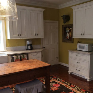 Large kitchen pantry inspiration - Example of a large galley kitchen pantry design in Birmingham with a farmhouse sink, recessed-panel cabinets, white cabinets, quartzite countertops, yellow backsplash, glass tile backsplash, stainless steel appliances and an island
