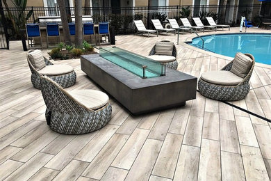 Inspiration for a large contemporary courtyard patio in Los Angeles with a fire feature, tile and no cover.