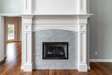 Living room - traditional medium tone wood floor living room idea in Other with a standard fireplace and a tile fireplace