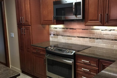Inspiration for a mid-sized timeless l-shaped vinyl floor eat-in kitchen remodel in Boston with an undermount sink, raised-panel cabinets, dark wood cabinets, quartz countertops, beige backsplash, stone tile backsplash, stainless steel appliances and an island