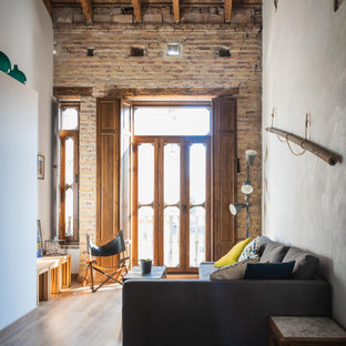 Ispirazione per un piccolo soggiorno industriale stile loft con pareti bianche, parquet scuro, travi a vista e pareti in mattoni