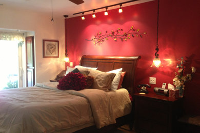 Diseño de dormitorio principal clásico de tamaño medio sin chimenea con paredes rojas, suelo de bambú y suelo marrón