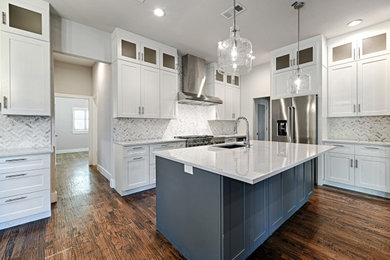 Inspiration for a transitional l-shaped medium tone wood floor and brown floor kitchen remodel in Dallas with an undermount sink, shaker cabinets, white cabinets, quartz countertops, gray backsplash, porcelain backsplash, stainless steel appliances, an island and white countertops