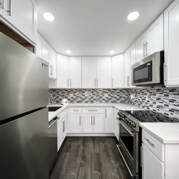 White U-shaped kitchen with stone countertops