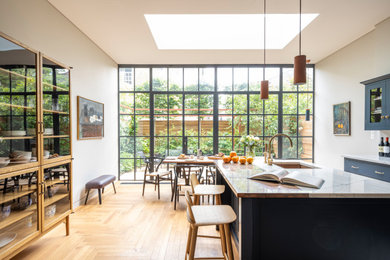 ロンドンにある高級な広いトランジショナルスタイルのおしゃれなキッチン (シェーカースタイル扉のキャビネット、青いキャビネット、クオーツストーンカウンター、白いキッチンカウンター) の写真