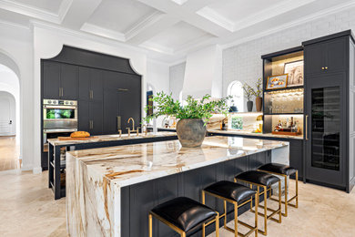 Example of a large tuscan kitchen design in Miami with a double-bowl sink, ceramic backsplash, black appliances and multicolored countertops