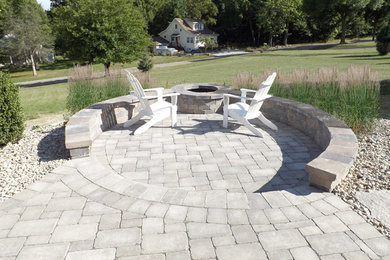 This is an example of a small contemporary backyard patio in Milwaukee with a fire feature and brick pavers.
