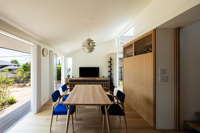 Inspiration for a scandinavian open plan dining in Kobe with white walls, medium hardwood floors and brown floor.