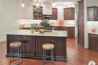 Example of a mid-sized minimalist medium tone wood floor eat-in kitchen design in Wichita with an undermount sink, raised-panel cabinets, granite countertops, beige backsplash, mosaic tile backsplash, stainless steel appliances and an island