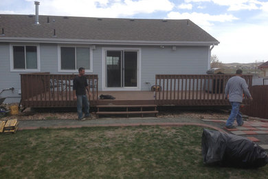 Elegant backyard deck photo in Denver with a roof extension