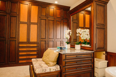 Closet - huge traditional marble floor and white floor closet idea in Denver with raised-panel cabinets and medium tone wood cabinets