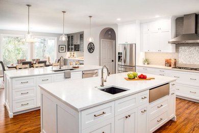 Inspiration for a large coastal u-shaped medium tone wood floor and brown floor eat-in kitchen remodel in Portland with a single-bowl sink, shaker cabinets, white cabinets, quartz countertops, gray backsplash, glass tile backsplash, stainless steel appliances, two islands and white countertops