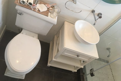 Inspiration for a small modern 3/4 white tile and ceramic tile slate floor and black floor walk-in shower remodel in Denver with furniture-like cabinets, white cabinets, a two-piece toilet, white walls, a vessel sink, concrete countertops, a hinged shower door and gray countertops