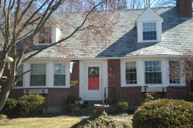 Example of a mid-sized red two-story brick gable roof design in Philadelphia