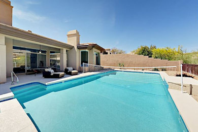 Ejemplo de piscina natural minimalista grande a medida en patio trasero