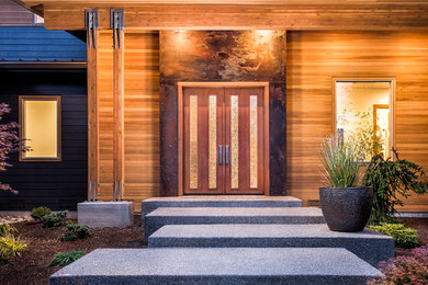 Inspiration for a contemporary concrete floor entryway remodel in Seattle with a medium wood front door