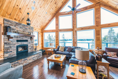Living room - large rustic open concept dark wood floor and brown floor living room idea in Other with a standard fireplace and a stone fireplace