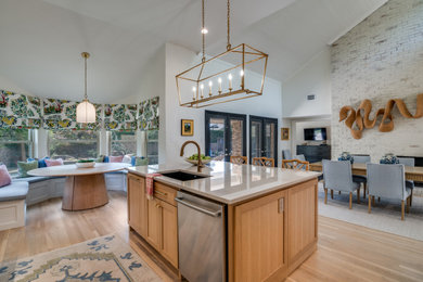 Mid-sized transitional l-shaped light wood floor, brown floor and vaulted ceiling eat-in kitchen photo in Dallas with an undermount sink, shaker cabinets, medium tone wood cabinets, quartzite countertops, white backsplash, stone slab backsplash, stainless steel appliances, an island and white countertops