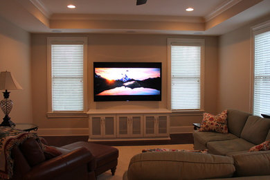 Example of a mid-sized classic open concept carpeted family room design in Atlanta with beige walls, a standard fireplace, a concrete fireplace and a media wall