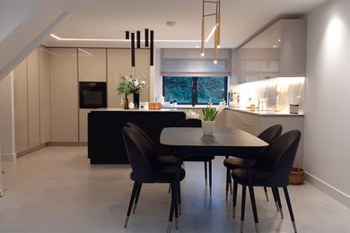 バッキンガムシャーにある高級な広いコンテンポラリースタイルのおしゃれなキッチン (シングルシンク、フラットパネル扉のキャビネット、珪岩カウンター、白いキッチンパネル、黒い調理設備、白いキッチンカウンター) の写真