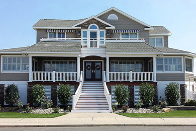 Inspiration for a large contemporary gray three-story exterior home remodel in New York with a hip roof