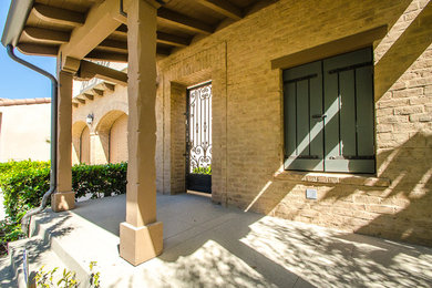 Inspiration for a mid-sized contemporary beige two-story brick gable roof remodel in Orange County