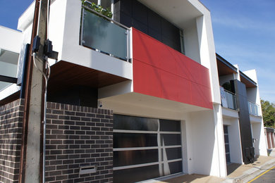 Inspiration for a large contemporary two-storey exterior in Adelaide with concrete fiberboard siding and a flat roof.
