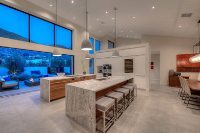 Example of a large trendy gray floor open concept kitchen design in Phoenix with a double-bowl sink, flat-panel cabinets, white cabinets, quartzite countertops, stainless steel appliances, two islands and gray countertops