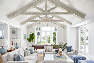 Example of a beach style open concept light wood floor, beige floor, exposed beam, shiplap ceiling and vaulted ceiling family room design in Other with white walls and no fireplace