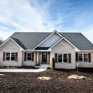 Пример оригинального дизайна интерьера: фасад частного дома розового цвета в стиле кантри с облицовкой из винила и крышей из гибкой черепицы