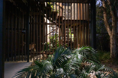 This is an example of a small and australian native contemporary backyard partial sun garden in Brisbane with with rock feature and a wood fence.