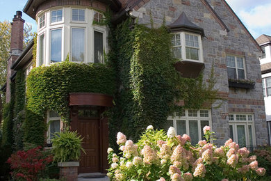 Example of a mid-sized classic two-story stone gable roof design in Montreal