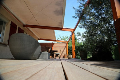 Design ideas for a mid-sized contemporary backyard patio in Paris with a pergola.